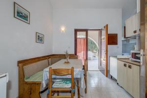 Una cocina y un comedor con mesa y sillas. en Apartment Natasa, en Rogoznica