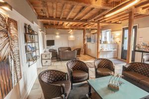 ein Wohnzimmer mit Stühlen, einem Tisch und einem Zimmer in der Unterkunft Logis Hôtel la Grassinais Saint-Malo in Saint-Malo