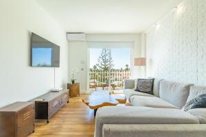 a living room with a couch and a tv at Luxury Loft en Maspalomas con Terraza y Piscina in Maspalomas
