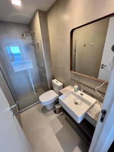 uma casa de banho com um WC, um lavatório e um espelho. em UNU Beach Class Ondina em Salvador