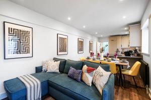 uma sala de estar com um sofá azul e uma mesa em Stunning Abode in London - Private Garden em Londres