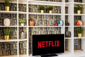 a tv on a shelf with the netflix sign on it at Stunning Abode in London - Private Garden in London