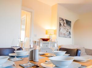 una mesa de comedor con platos blancos y copas de vino en Newly refurbished apartment in city centre, en Hereford