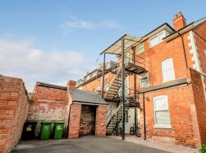 a brick building with a fire ladder on it at Newly refurbished apartment in city centre in Hereford