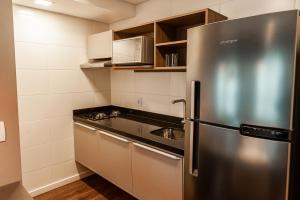 a kitchen with a stainless steel refrigerator and a sink at Quality Porto Alegre in Porto Alegre