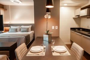 a small room with a bed and a table with chairs at Quality Porto Alegre in Porto Alegre
