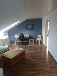 uma sala de estar com uma secretária, um sofá e uma mesa em Wohnung mit Blick aufs Blockland em Osterholz-Scharmbeck
