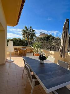 a patio with a blue table and chairs and an umbrella at R26 Stunning Penthouse Duplex Elviria in Marbella