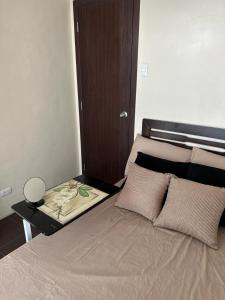 a small bedroom with a bed with a wooden headboard at 2BR Top Floor spacious unit in Mandaluyong in Manila