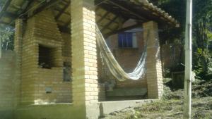 um pequeno edifício de tijolos com rede em Casa no Centro de Ibitipoca em Lima Duarte