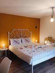 um quarto com uma cama branca e uma parede amarela em Bricco Nebbiolo em Neviglie