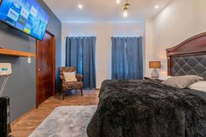 una camera con un grande letto e una TV di Elegante Condo CentroHistórico con Cochera a Durango