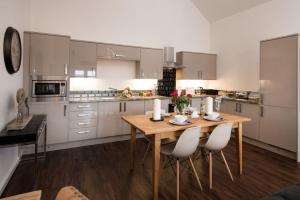 a kitchen with a wooden table and white cabinets at Byre in Melrose