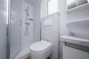 biała łazienka z toaletą i prysznicem w obiekcie MOBILE HOMES SELCE - Lighthouse w mieście Selce