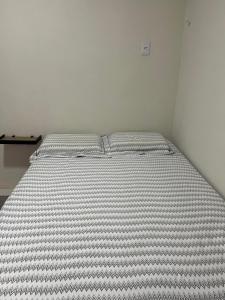 uma cama num quarto branco com um colchão em Excelentes Quartos com banheiros privativos em Recife