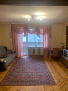 ein Wohnzimmer mit einem großen Fenster mit rosa Vorhängen in der Unterkunft Апартаменты на пр Гагарина in Dnipro