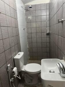 a bathroom with a toilet and a sink at Excelentes Quartos com banheiros privativos in Recife