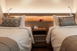 a hotel room with two beds and a table at Quality Porto Alegre in Porto Alegre