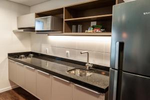 a kitchen with a sink and a refrigerator at Quality Porto Alegre in Porto Alegre