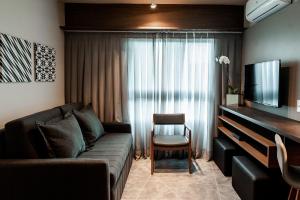 a living room with a couch and a television at Quality Porto Alegre in Porto Alegre