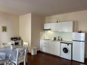 Il comprend une cuisine équipée d'une table et d'un réfrigérateur blanc. dans l'établissement LA CASA DI ANDREA, à Taormine