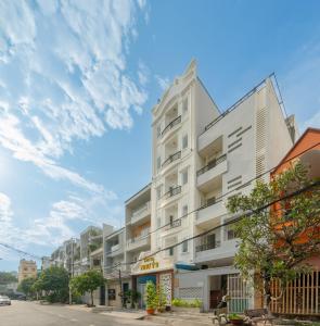 a white building on a street with a cloudy sky at Hotel Nhu Y 2 in Ho Chi Minh City