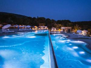 a large swimming pool with blue water at night at MOBILE HOMES SELCE - Lighthouse in Selce