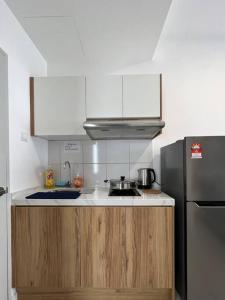 a kitchen with a sink and a refrigerator at The Deluxe at Horizon Suites KLIA in Kampong Melot
