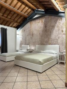 2 letti in una camera da letto con muro di mattoni di Villa Roberta B&B a Ferrara