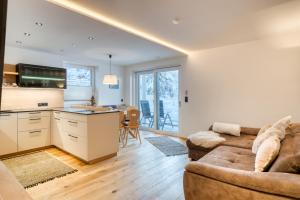 Il comprend un salon avec un canapé et une cuisine. dans l'établissement INN Sun Apartment, à Innsbruck