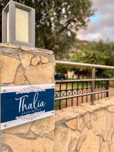 a sign for a hotel on a stone wall at Thalia Apartments in Agia Galini