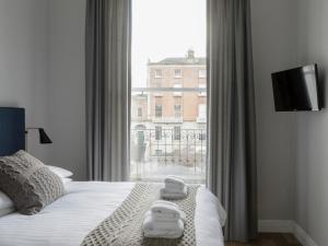 a bedroom with a bed and a large window at Pembroke Hall in Dublin