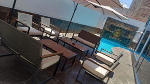 un ristorante vuoto con tavoli e sedie e un ombrellone di RESIDENCIAL CARMANI a Tacna