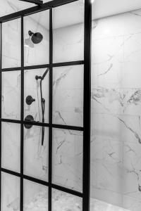 een douche in een badkamer met een glazen deur bij The Phenix Historic DTWN Hotel, Room # 310 in Bangor