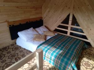 a bed in a wooden cabin with a bed sidx sidx sidx sidx at Birlik Yaylakent in Sultan Murat Yaylasi