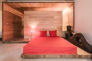 una camera con letto rosso e cuscini rossi di Dichterstube im Living Kampill a Bolzano