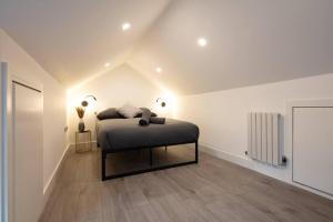 a bedroom with a bed in a white room at Cosy 1 Bed Duplex - Close to Metro - NW2 in London