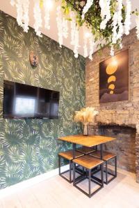 a dining room with a table and a tv on a wall at Cosy 1 Bed Duplex - Close to Metro - NW2 in London