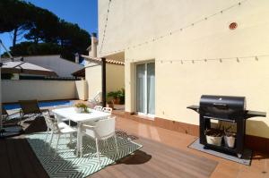 d'une terrasse avec une table blanche et un grill. dans l'établissement Casa Cossis, à L'Escala