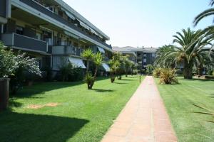 a walkway in front of a building with palm trees at Residence Leonardo in Silvi Marina