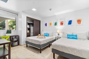 a bedroom with two beds and a table in it at Beautiful Vibes Sun Kiss Serenity your Stylish Apt Just Steps from Eagle Beach in Palm-Eagle Beach +42 photos