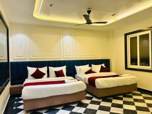 2 Betten in einem Hotelzimmer mit in der Unterkunft Taj Ronak Luxury Hotels in Agra