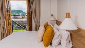 a bedroom with a bed with yellow pillows and a window at Del Mar Guest House in Cartagena de Indias