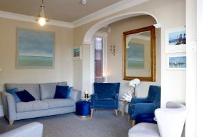 a living room with blue chairs and a couch at The New England in Eastbourne