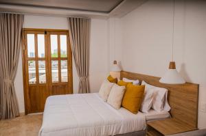 sypialnia z białym łóżkiem z żółtymi poduszkami w obiekcie Del Mar Guest House w mieście Cartagena de Indias
