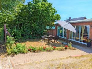 a house with a patio with a table and an umbrella at W5 - Urlaubsmagie - Wohnung mit Grill, Terrasse & Pool in Lichtenhain