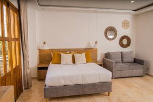 um quarto com uma cama e uma cadeira em Del Mar Guest House em Cartagena de Indias