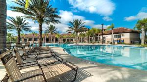 uma piscina com bancos e palmeiras em Solterra Resort World Of Imagination 7364 em Davenport