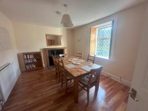 3 Bed Cottage in the Peaceful Village Wanlockhead في Wanlockhead: غرفة طعام مع طاولة وكراسي خشبية