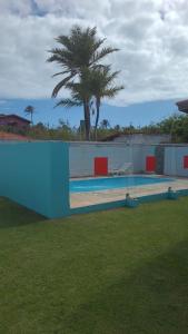 een zwembad met een palmboom op de achtergrond bij Casa Laser praia Cumbuco in Cumbuco